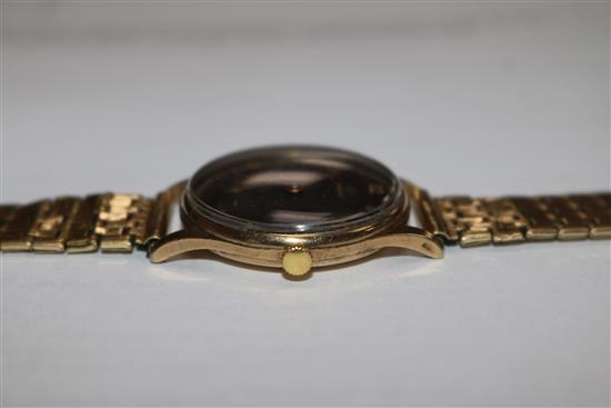 A gentlemans 1940s 9ct gold Omega wrist manual wind watch, with black Arabic dial on rolled gold bracelet.